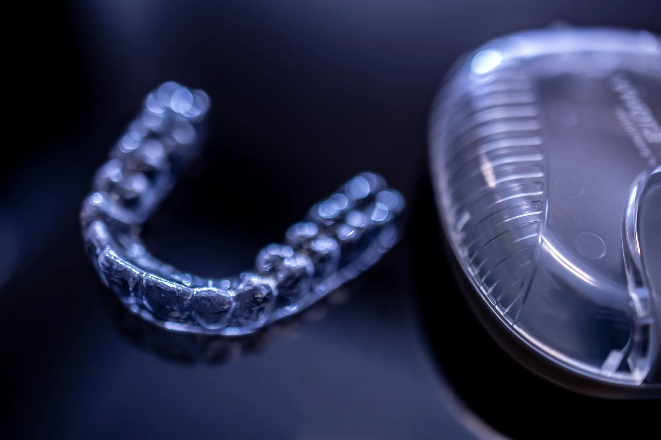Invisalign retainer and case on glass table